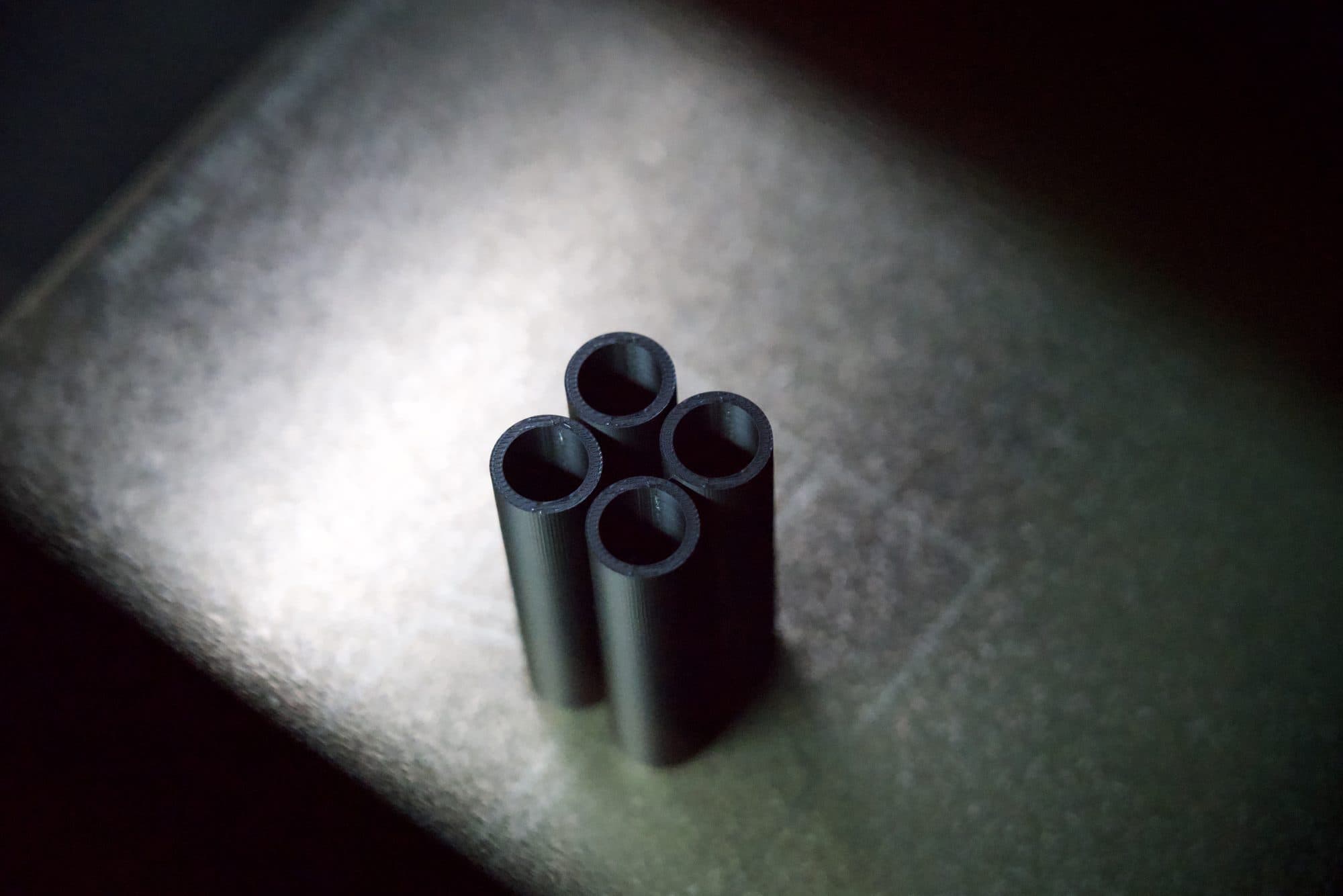 Vier präzise gefertigte Objekte im Lichtkegel
